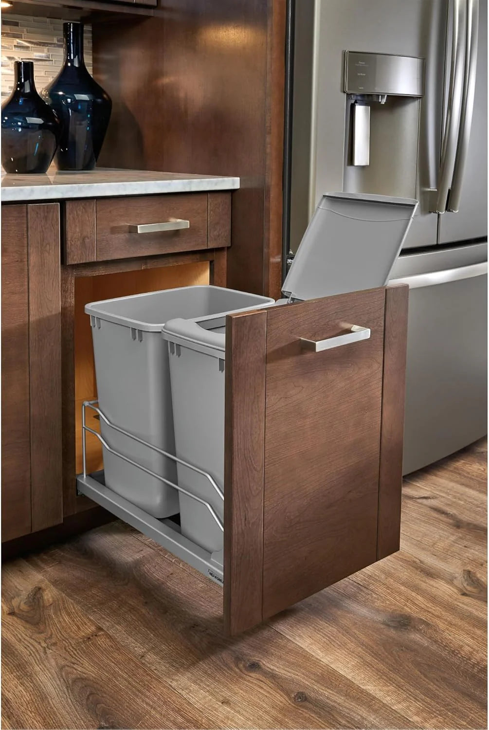 A double pull-out trash can suitable for the bottom of kitchen cabinets. with a capacity of 35 ounces (approximately 0.875 gallons). equipped with a gentle closing sliding mechanism. and in the color of Orison Gray.